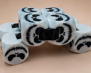 Glow-white 3D-printed fidget made of linked cubes with stitched-smile Halloween faces